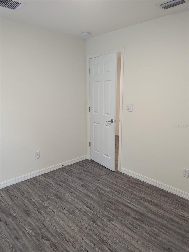 spare room with dark wood-type flooring