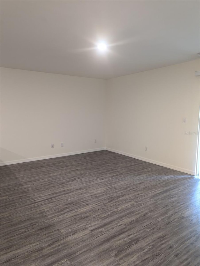 unfurnished room with dark hardwood / wood-style flooring