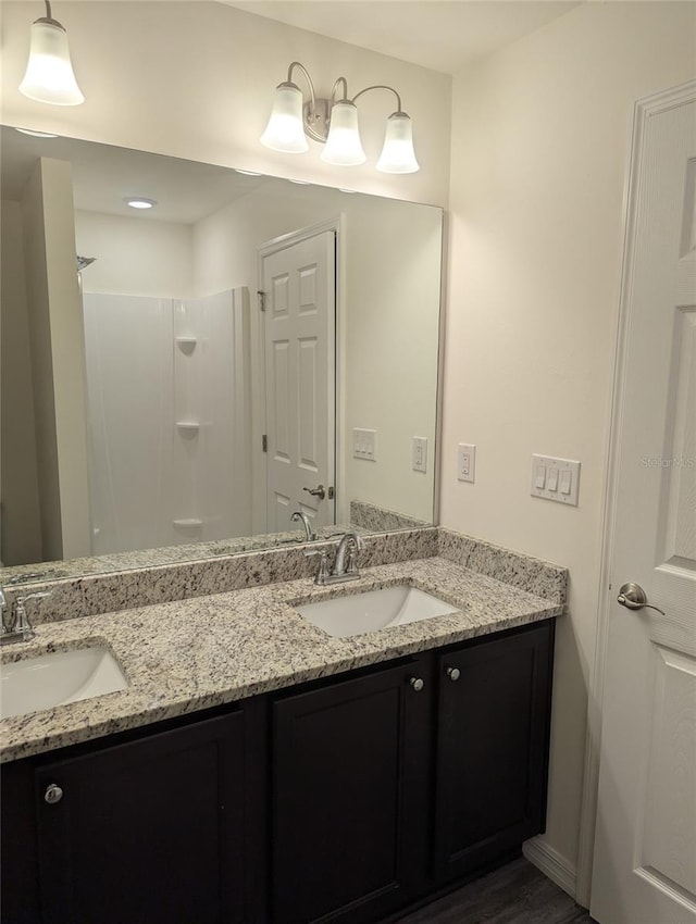 bathroom featuring walk in shower, vanity, and hardwood / wood-style floors