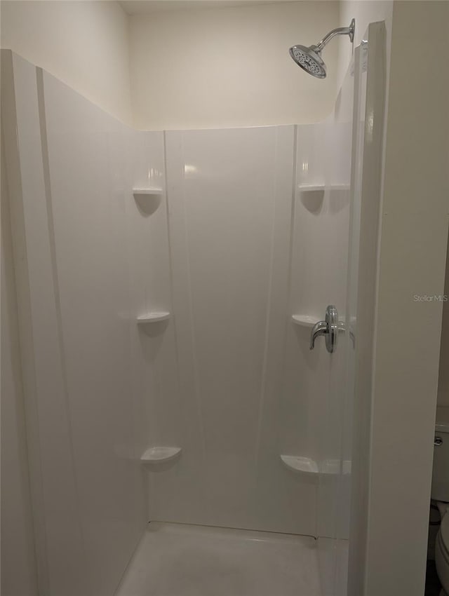 bathroom featuring a shower and toilet