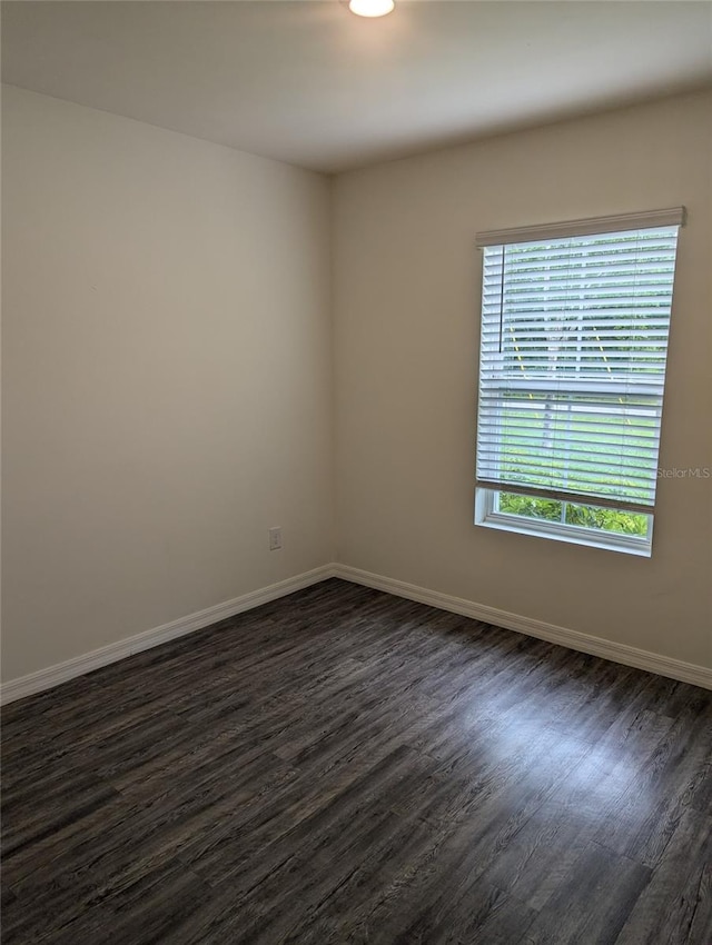 unfurnished room with dark hardwood / wood-style flooring