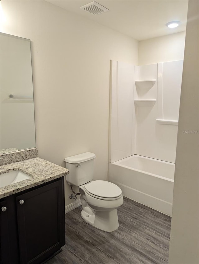 full bathroom featuring shower / tub combination, hardwood / wood-style floors, vanity, and toilet