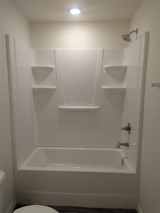 bathroom featuring shower / bath combination and toilet