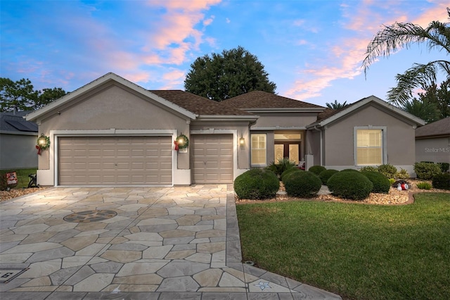 view of front facade with a yard and a garage