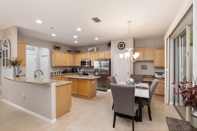 kitchen featuring appliances with stainless steel finishes, kitchen peninsula, and light tile patterned floors