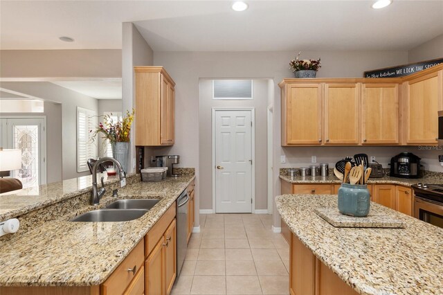 kitchen with stainless steel appliances, light tile patterned floors, sink, light brown cabinets, and light stone counters