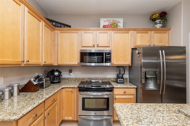 kitchen featuring light stone countertops and stainless steel appliances