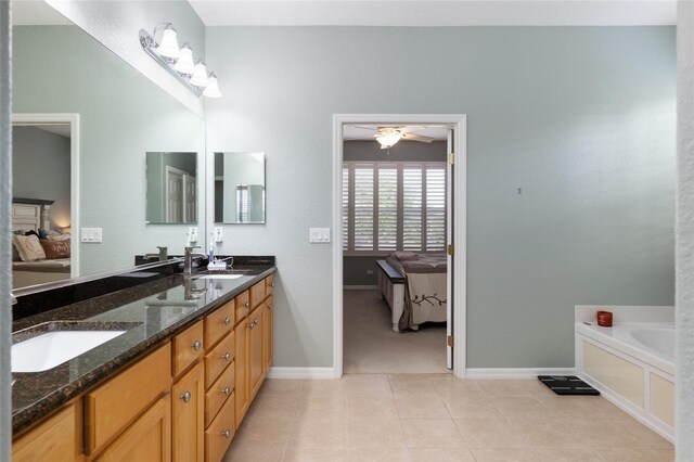 bathroom with ceiling fan, tile patterned floors, dual vanity, and a washtub