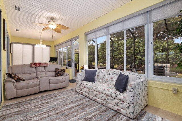 sunroom / solarium with ceiling fan with notable chandelier