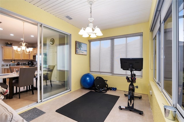 workout area featuring light tile patterned floors and an inviting chandelier