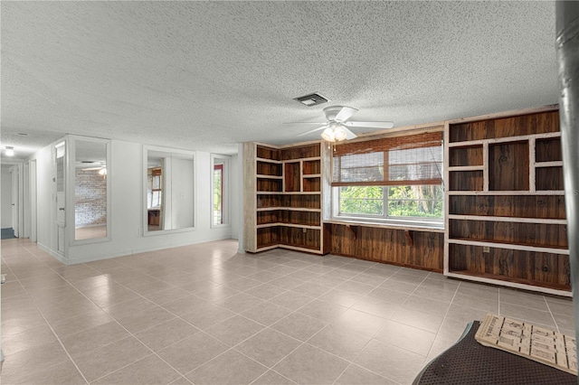 unfurnished living room featuring light tile patterned flooring, a textured ceiling, and ceiling fan