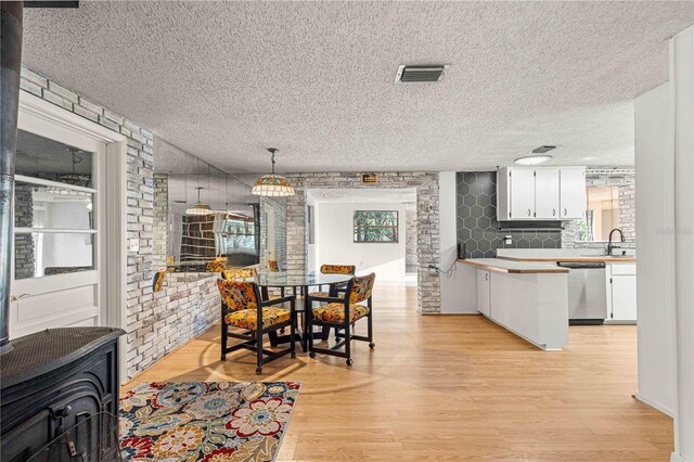 dining area featuring sink, light hardwood / wood-style flooring, and a textured ceiling