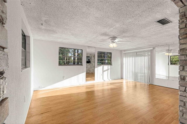 unfurnished room with ceiling fan, a textured ceiling, and light hardwood / wood-style floors