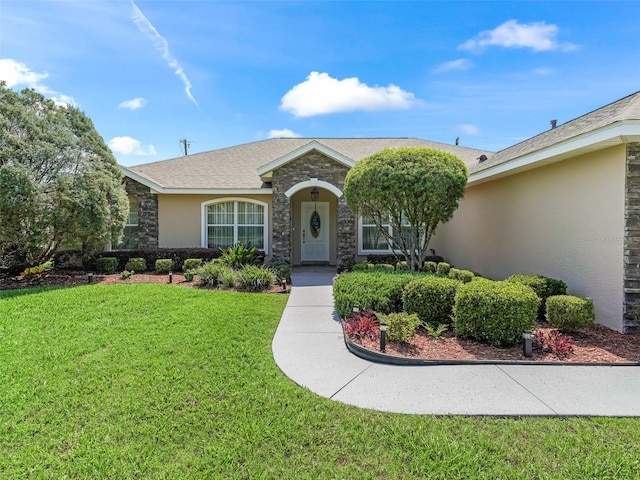 view of front of property with a front yard, stone siding, and stucco siding