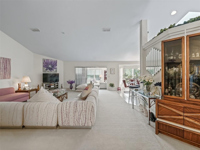 living room with high vaulted ceiling, carpet, and visible vents