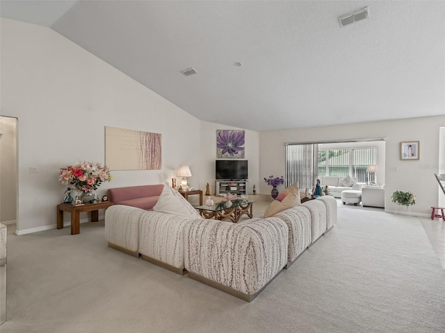 living area featuring high vaulted ceiling, visible vents, light carpet, and baseboards