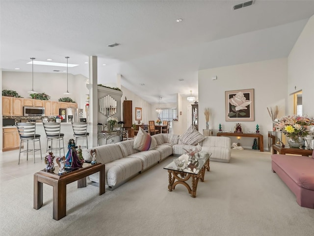 living area with lofted ceiling, visible vents, and light colored carpet