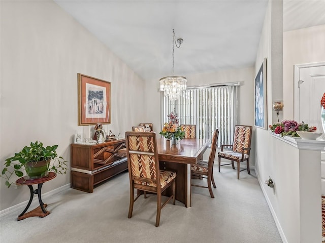 dining space with light colored carpet, a notable chandelier, and baseboards