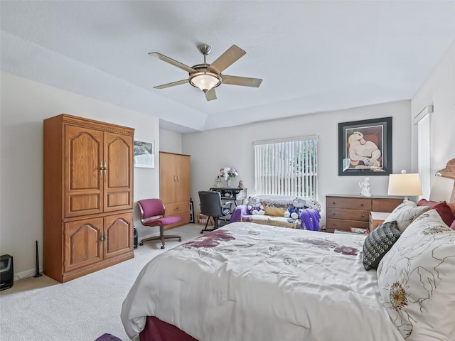 bedroom with a tray ceiling, a ceiling fan, and light colored carpet