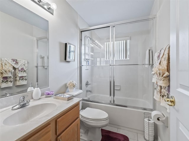 bathroom with toilet, tile patterned flooring, enclosed tub / shower combo, and vanity