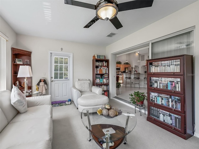 living room featuring visible vents, ceiling fan, and light carpet