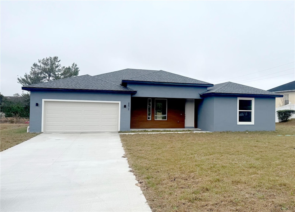 view of front of property with a garage and a front lawn