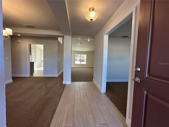 carpeted entryway with a textured ceiling