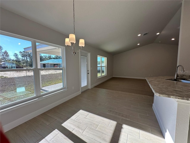 unfurnished dining area with hardwood / wood-style flooring, a healthy amount of sunlight, and sink