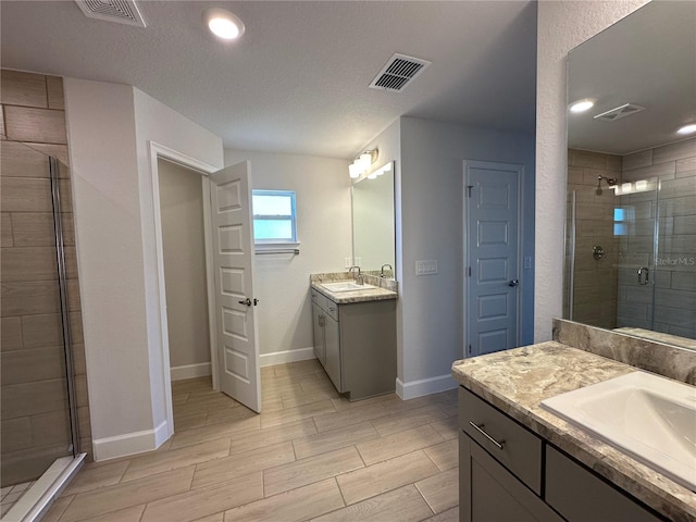 bathroom featuring vanity, a textured ceiling, and walk in shower