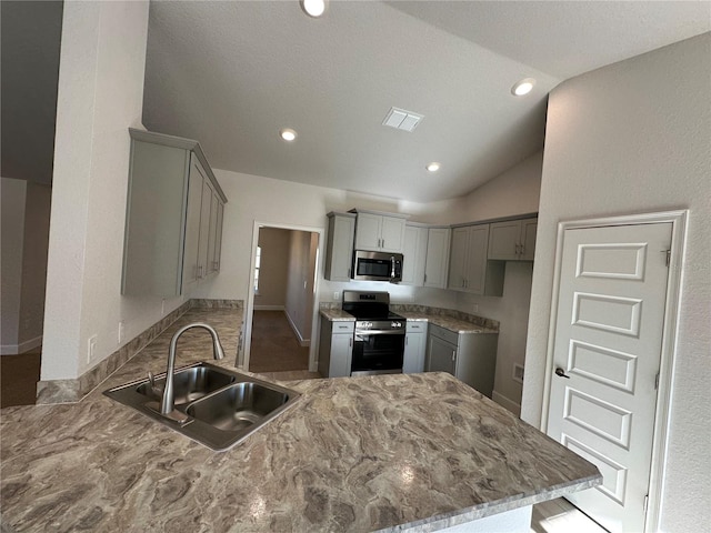 kitchen featuring lofted ceiling, sink, gray cabinets, kitchen peninsula, and stainless steel appliances