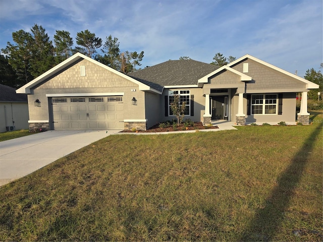 craftsman house with a garage and a front lawn