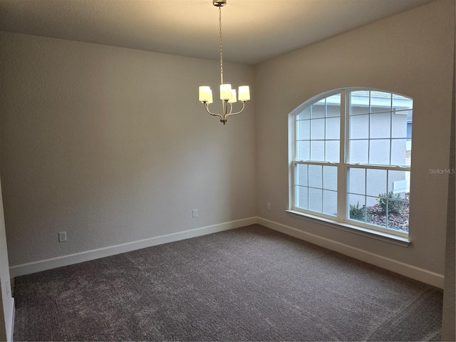 carpeted empty room featuring a notable chandelier