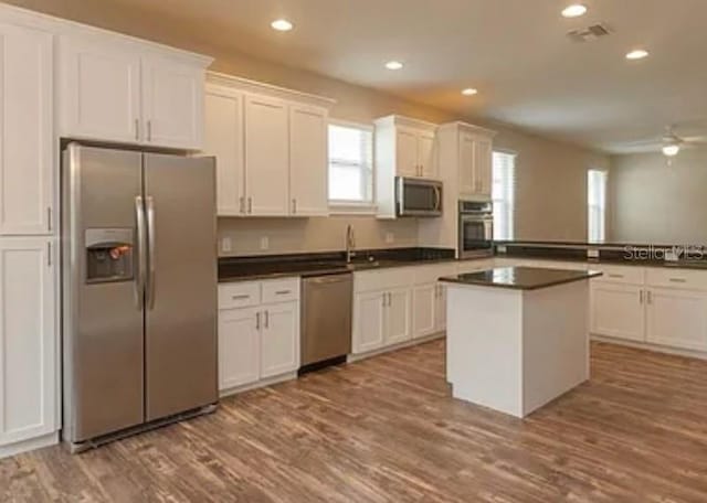 kitchen with ceiling fan, light hardwood / wood-style flooring, stainless steel appliances, and white cabinets