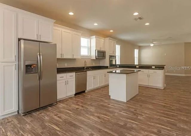 0 Fisher Lane Way, Ocklawaha, FL 32179 - kitchen with stainless steel appliances, dark countertops, dark wood-style floors, white cabinetry, and recessed lighting