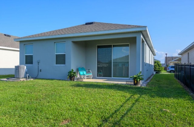 back of property featuring a patio area, a lawn, and central AC