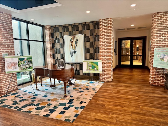 office area featuring brick wall, french doors, and hardwood / wood-style flooring