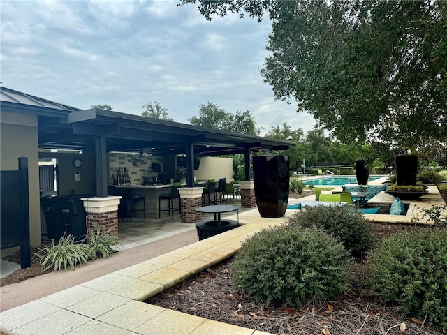 exterior space with an outdoor bar and a patio