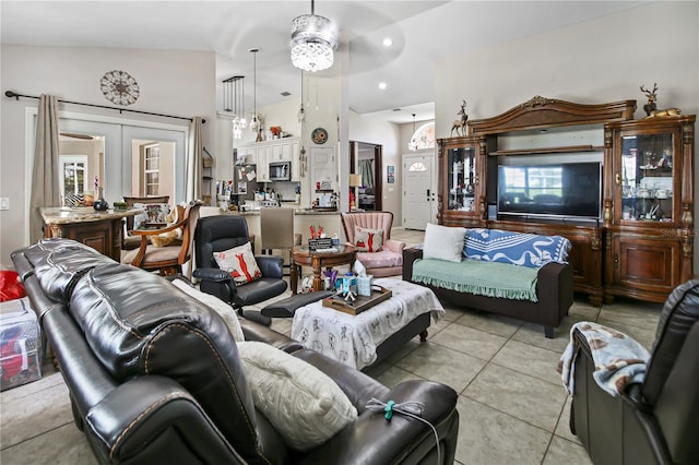 tiled living room with vaulted ceiling, french doors, and ceiling fan