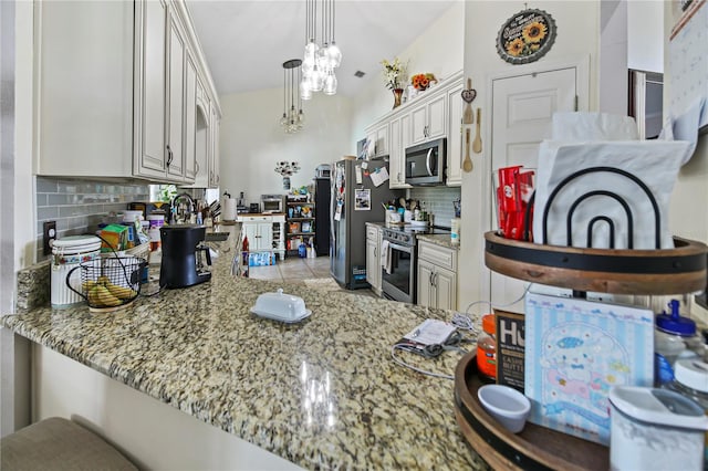 kitchen with white cabinets, backsplash, light stone countertops, appliances with stainless steel finishes, and kitchen peninsula