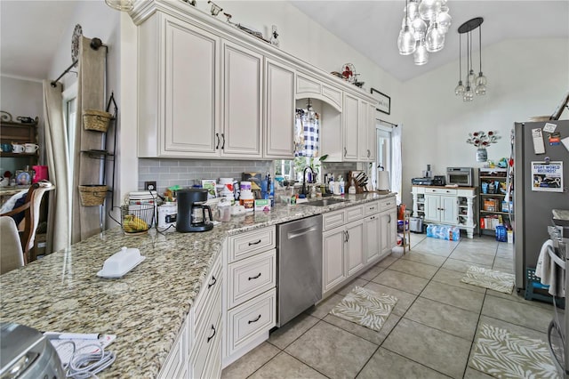 kitchen featuring a notable chandelier, sink, light stone countertops, appliances with stainless steel finishes, and lofted ceiling