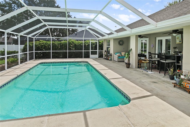 view of swimming pool with glass enclosure, outdoor lounge area, ceiling fan, and a patio