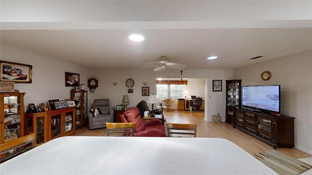 living room with ceiling fan and light hardwood / wood-style flooring