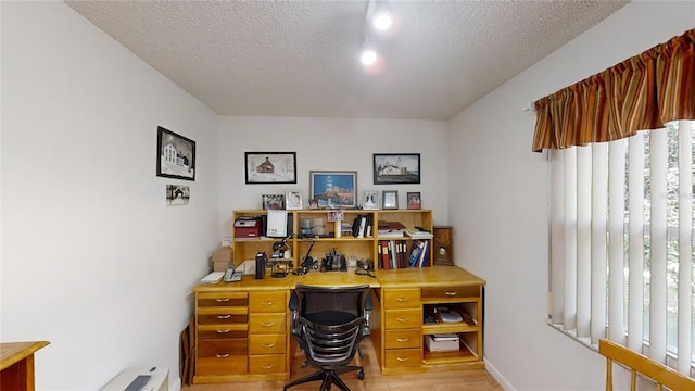 office with light hardwood / wood-style flooring and a textured ceiling