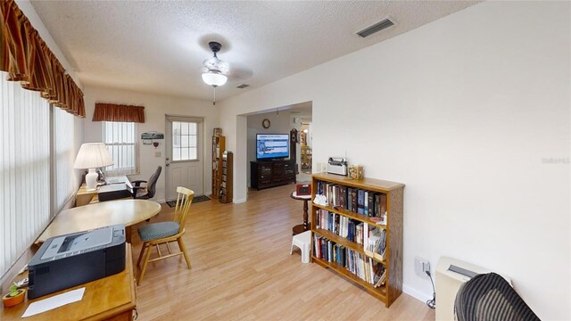 office featuring ceiling fan, a textured ceiling, and light hardwood / wood-style floors