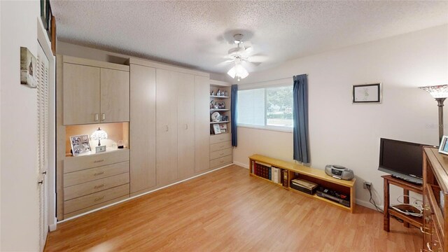 bedroom featuring ceiling fan, a textured ceiling, light hardwood / wood-style floors, and a closet