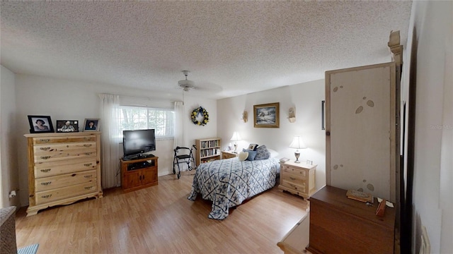 bedroom featuring ceiling fan, light wood-type flooring, and a textured ceiling