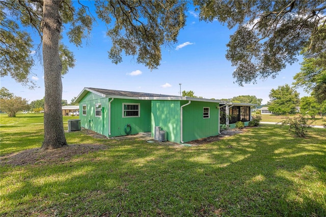 back of property with a lawn and central air condition unit