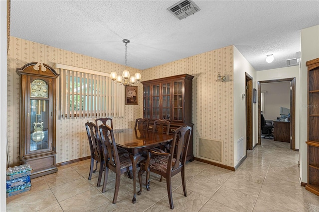 dining room with a notable chandelier, a textured ceiling, and light tile patterned floors