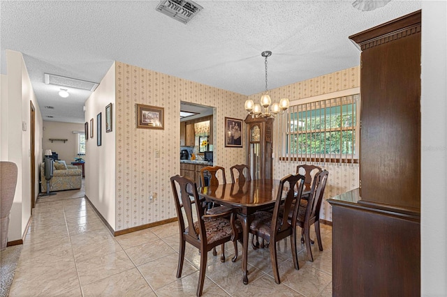 dining space with light tile patterned floors, a chandelier, and a textured ceiling