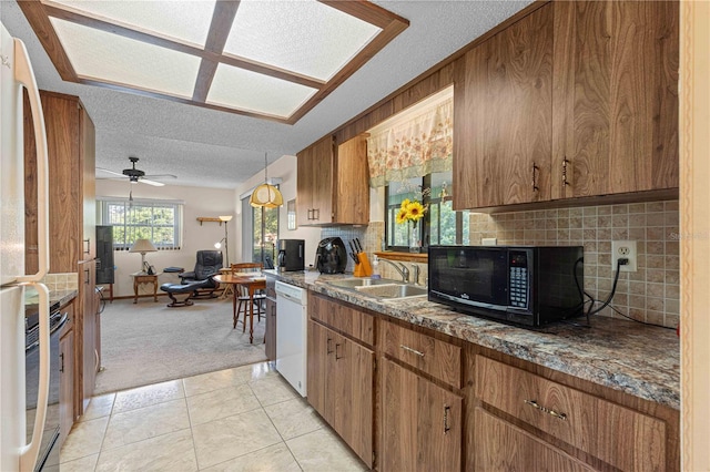 kitchen featuring white appliances, a textured ceiling, light carpet, backsplash, and ceiling fan